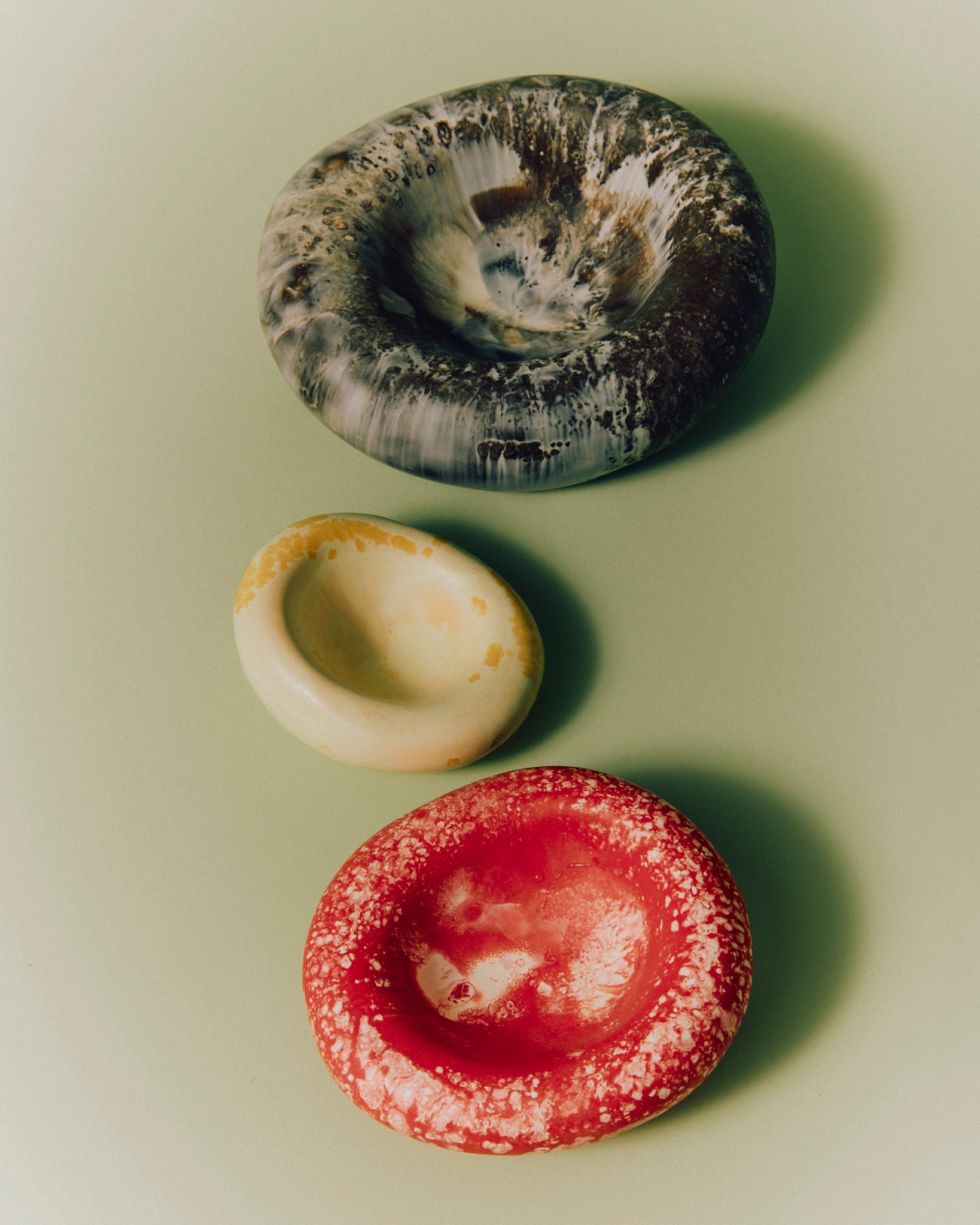 Resin Handmade Drift Dishes in Cappuccino (brown), Daisy (yellow) and Strawberry (red) colorways.